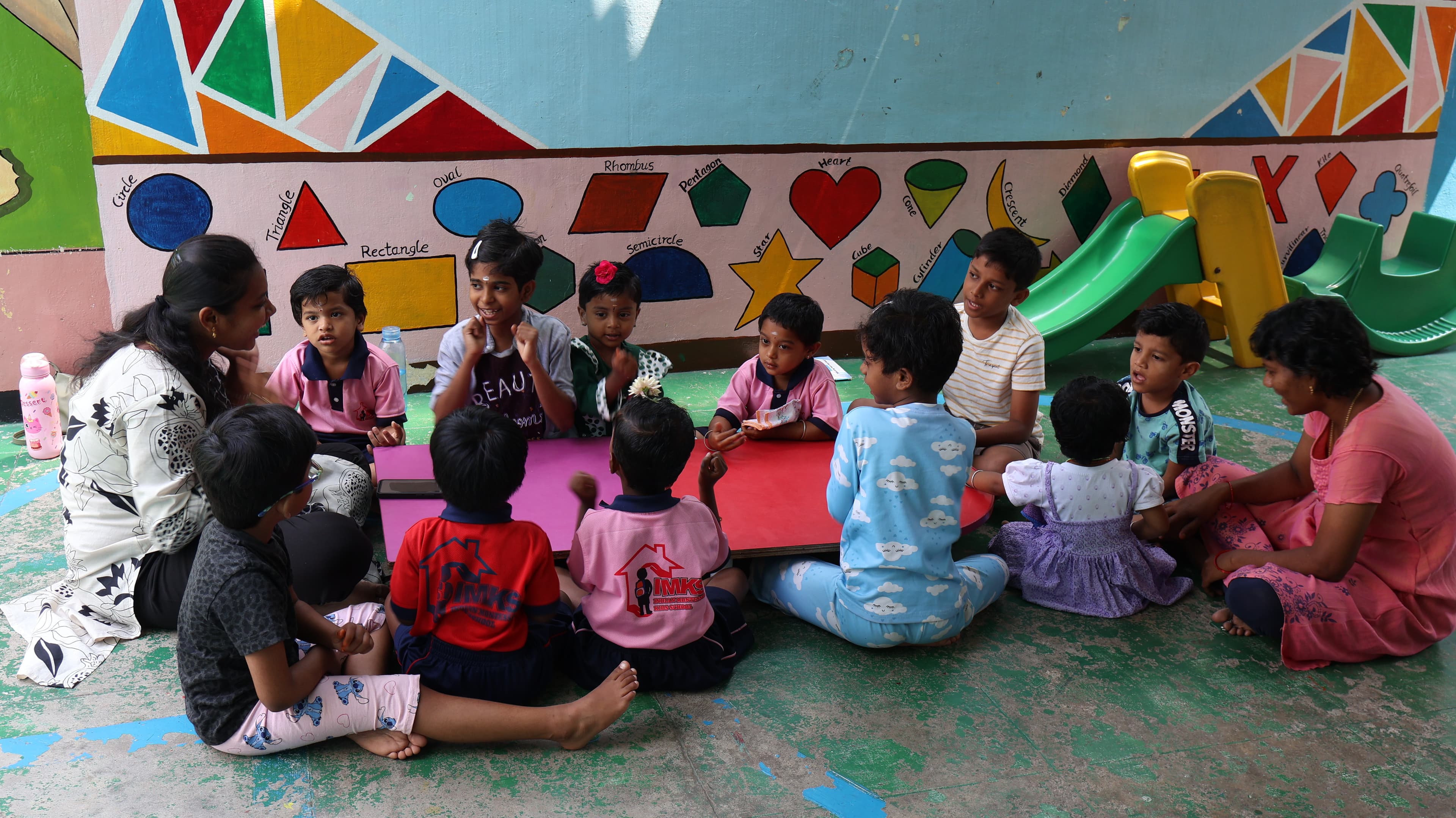 Teacher sitting with children during a Montessori activity